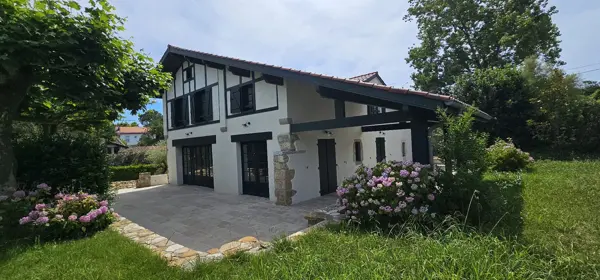 Fachada con terraza y jardín